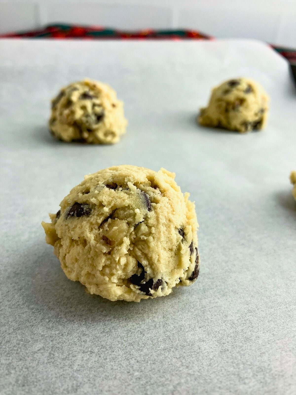 Walnut chocolate chip cookie dough balls on a baking sheet.