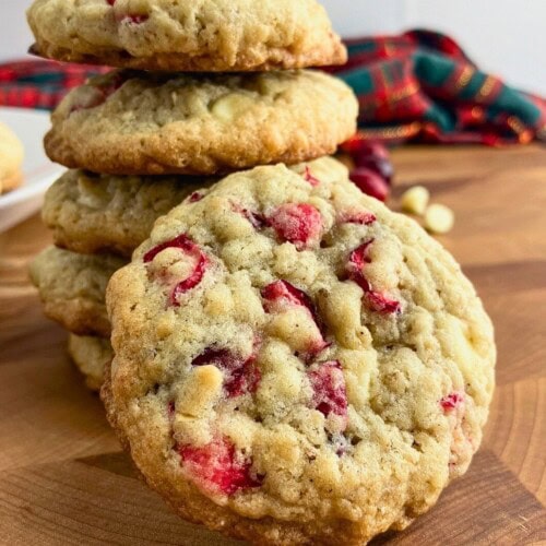 Homemade white chocolate cranberry oatmeal cookies on a wooden table.