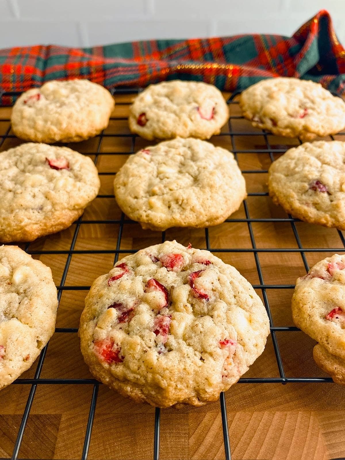 Cranberry and white chocolate chip oatmeal cookies are cooling on a wire rack.