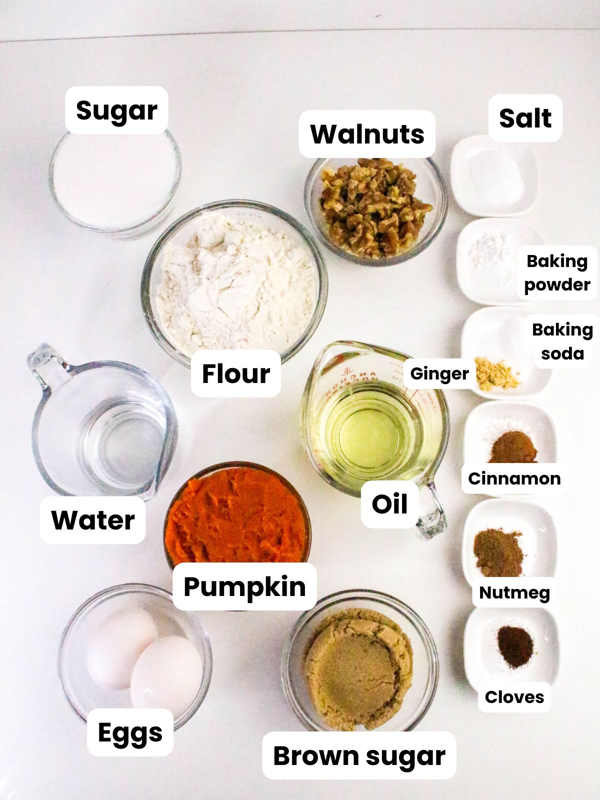 The ingredients for pumpkin bread are in individual bowls and measuring cups.