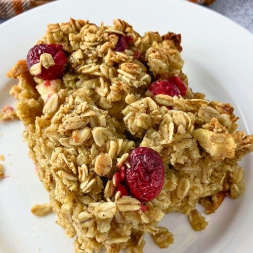 A slice of apple cranberry baked oatmeal on a white plate.