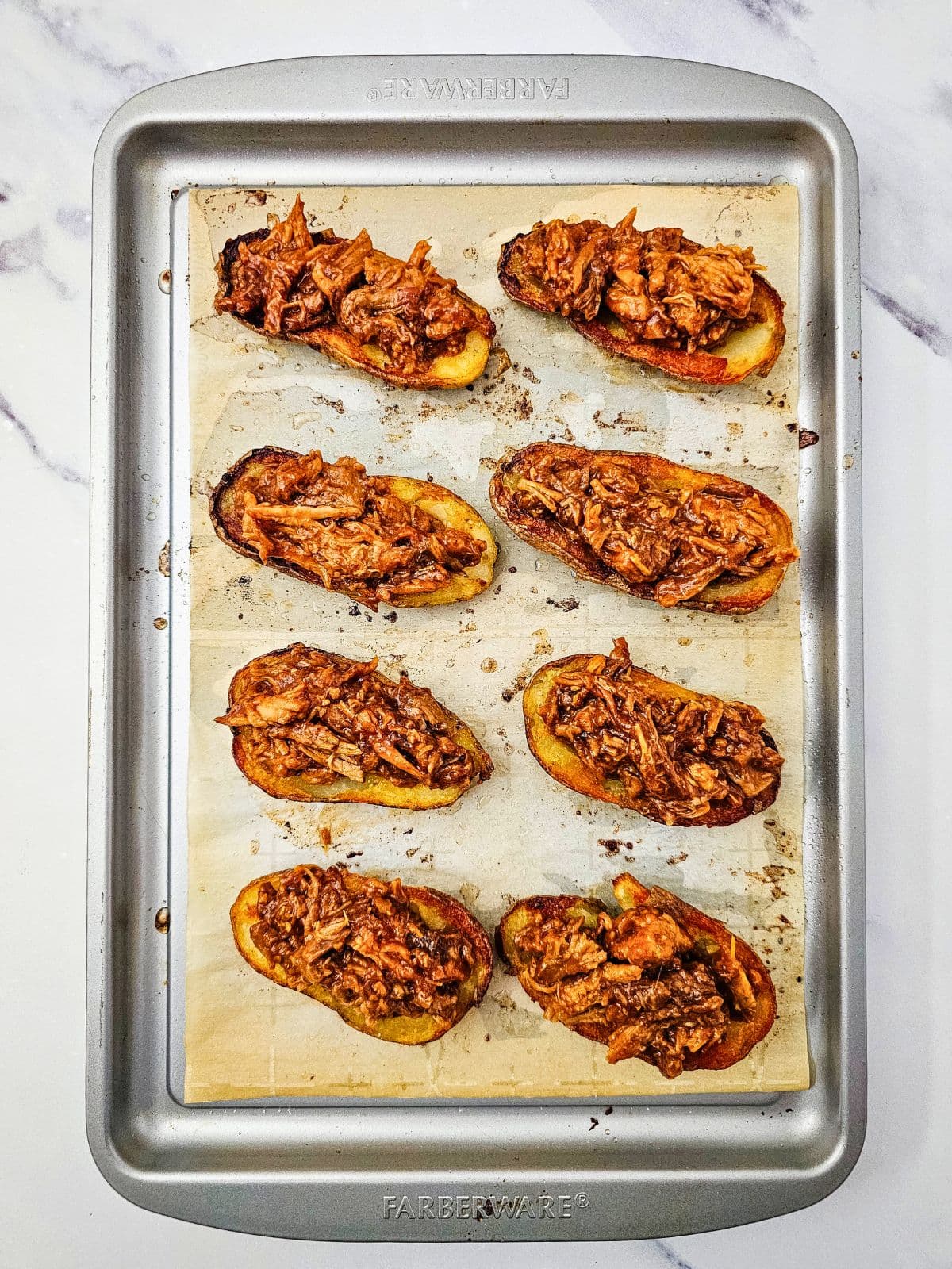 The potato centers have been filled with pulled pork.