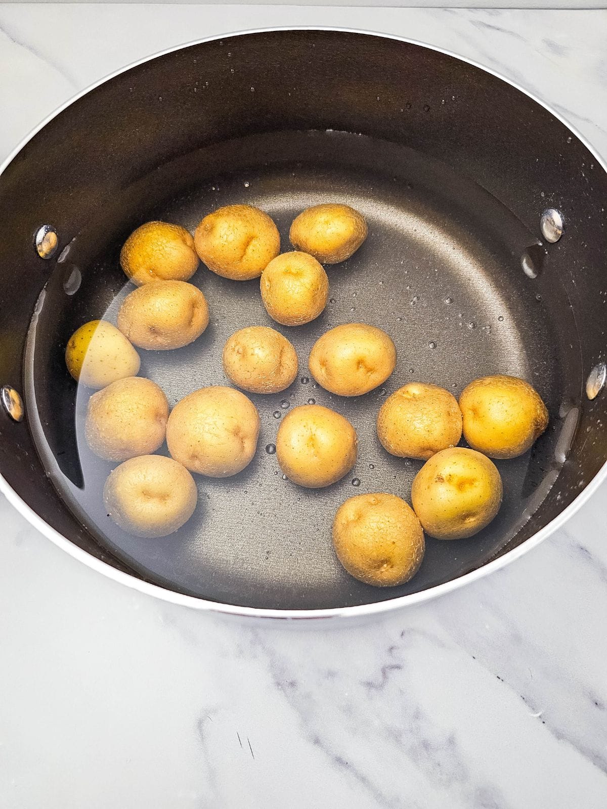 A pot of water with baby potatoes.