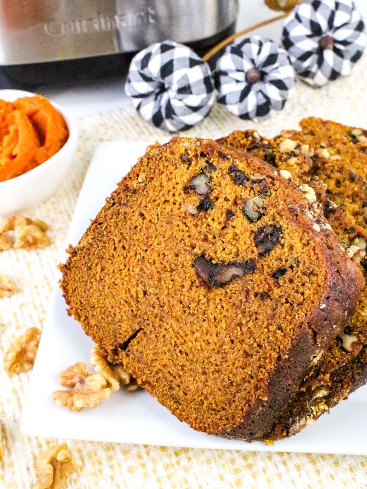 Three slices of bread machine made pumpkin bread, on a white plate.
