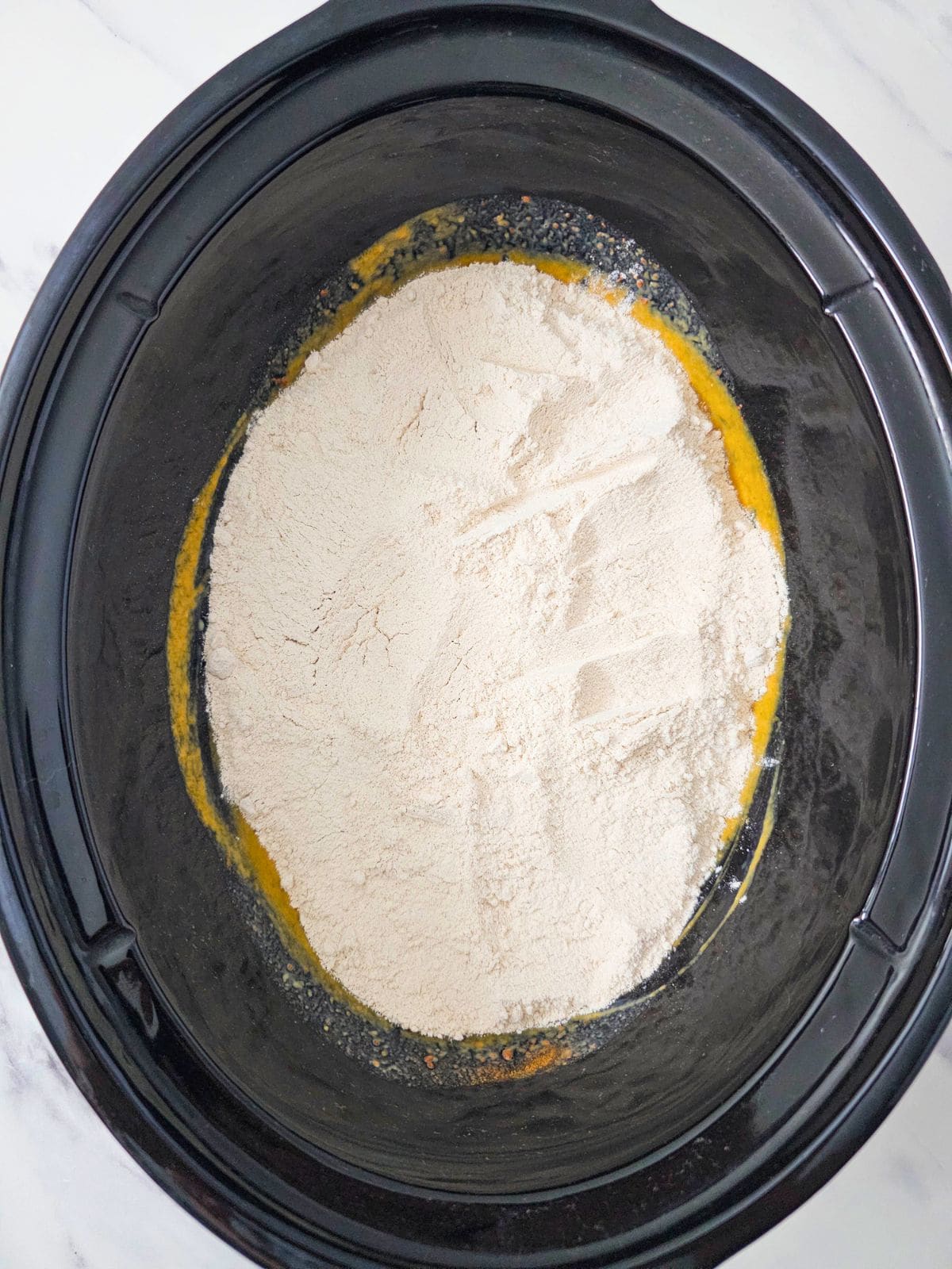 Spice cake mix sprinkled evenly over the pumpkin filling.