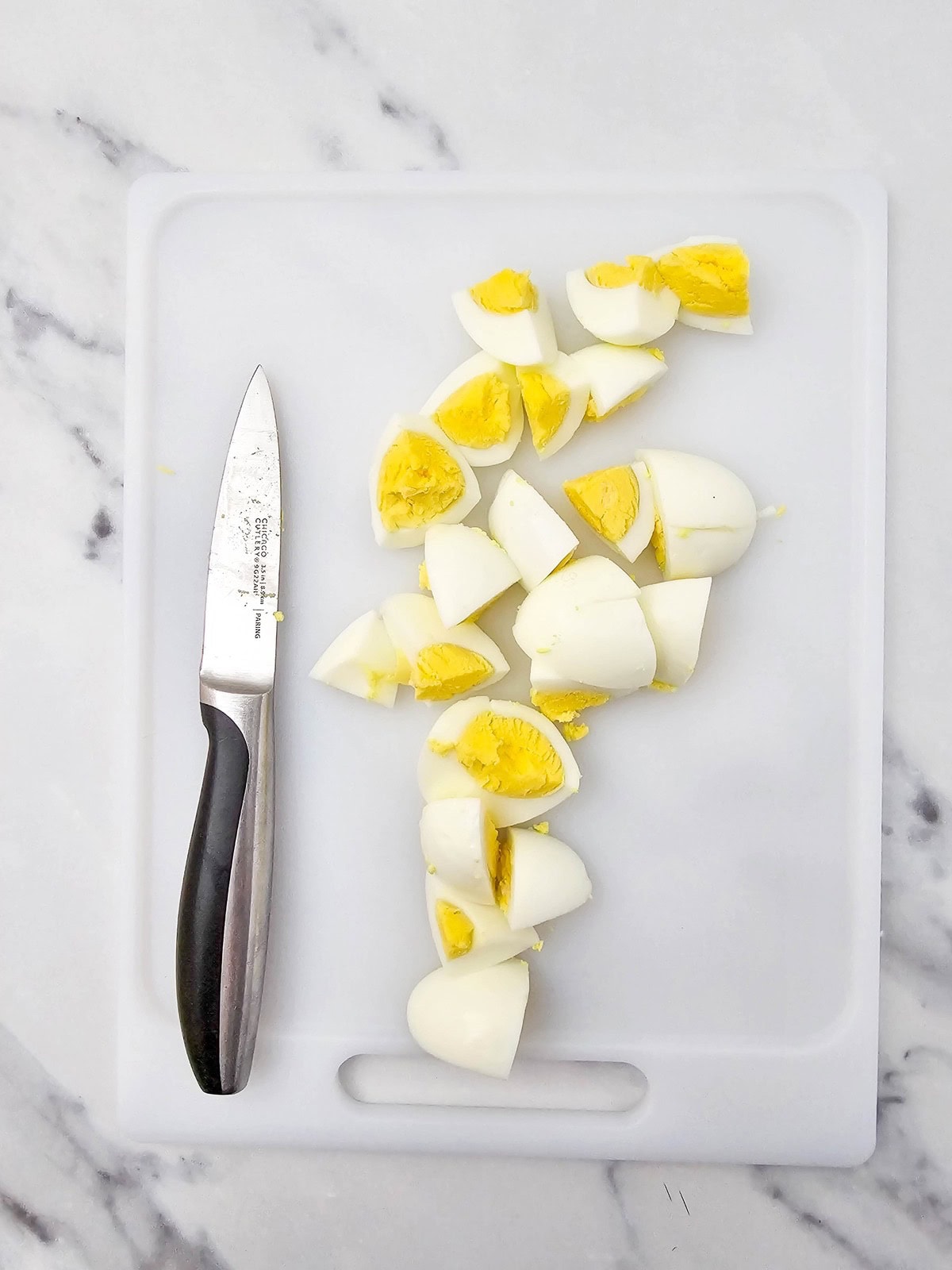 Chopped boiled eggs on a cutting board.