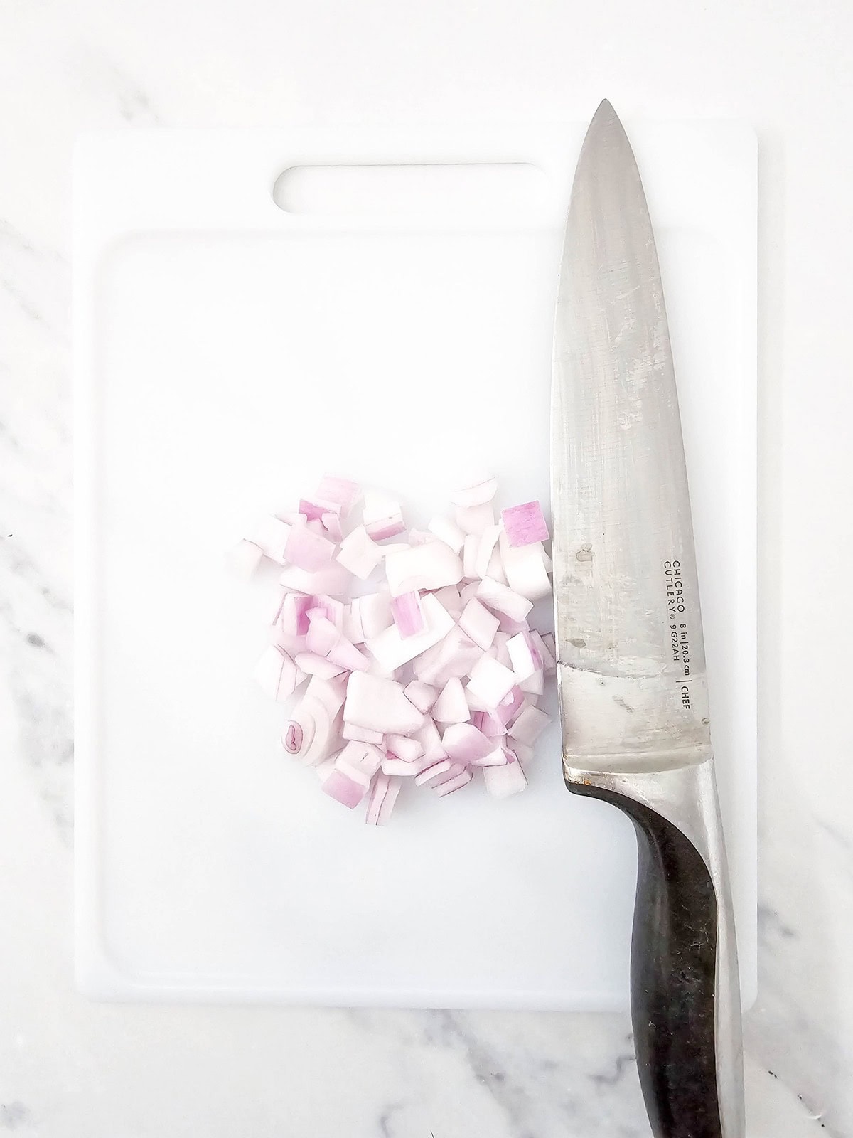 Diced red onions on a cutting board.