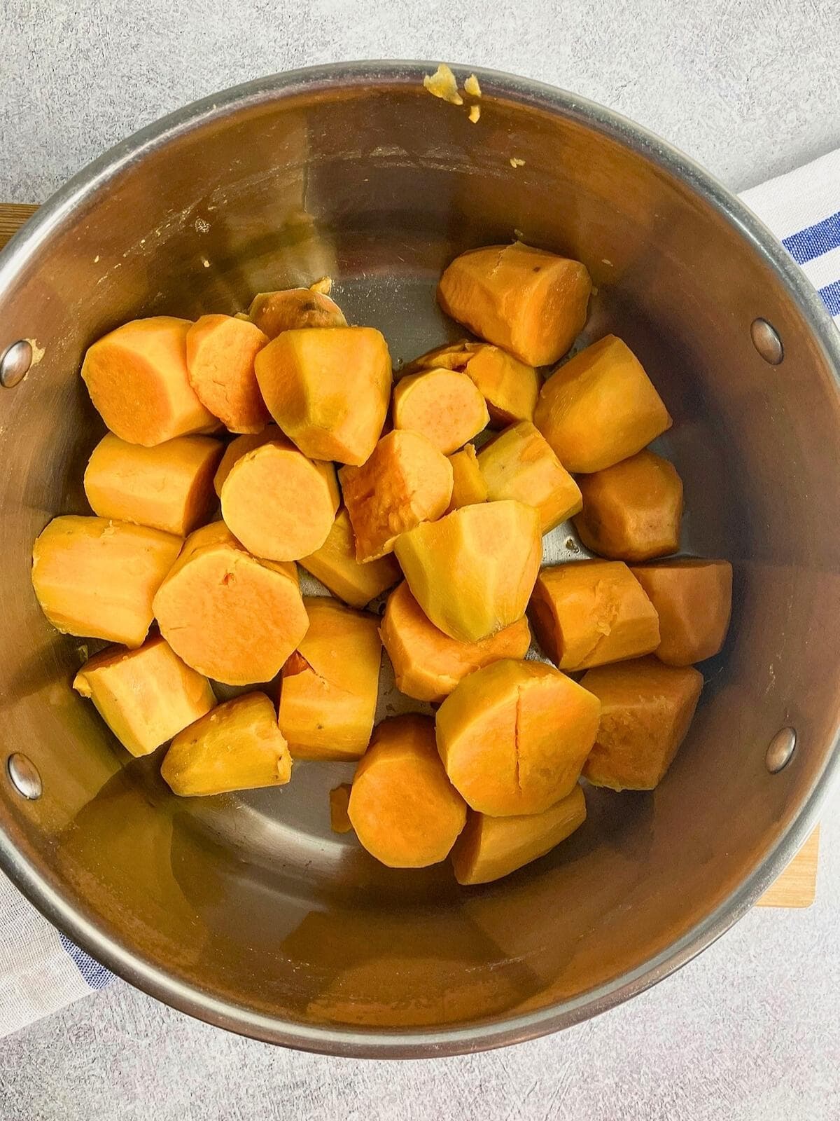 Sweet potatoes in a pot after cooking and draining.