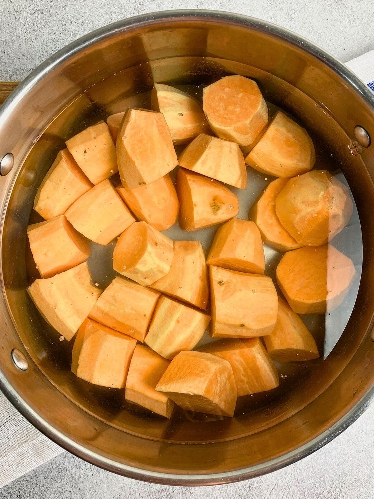 Cut sweet potatoes in a pot of water.