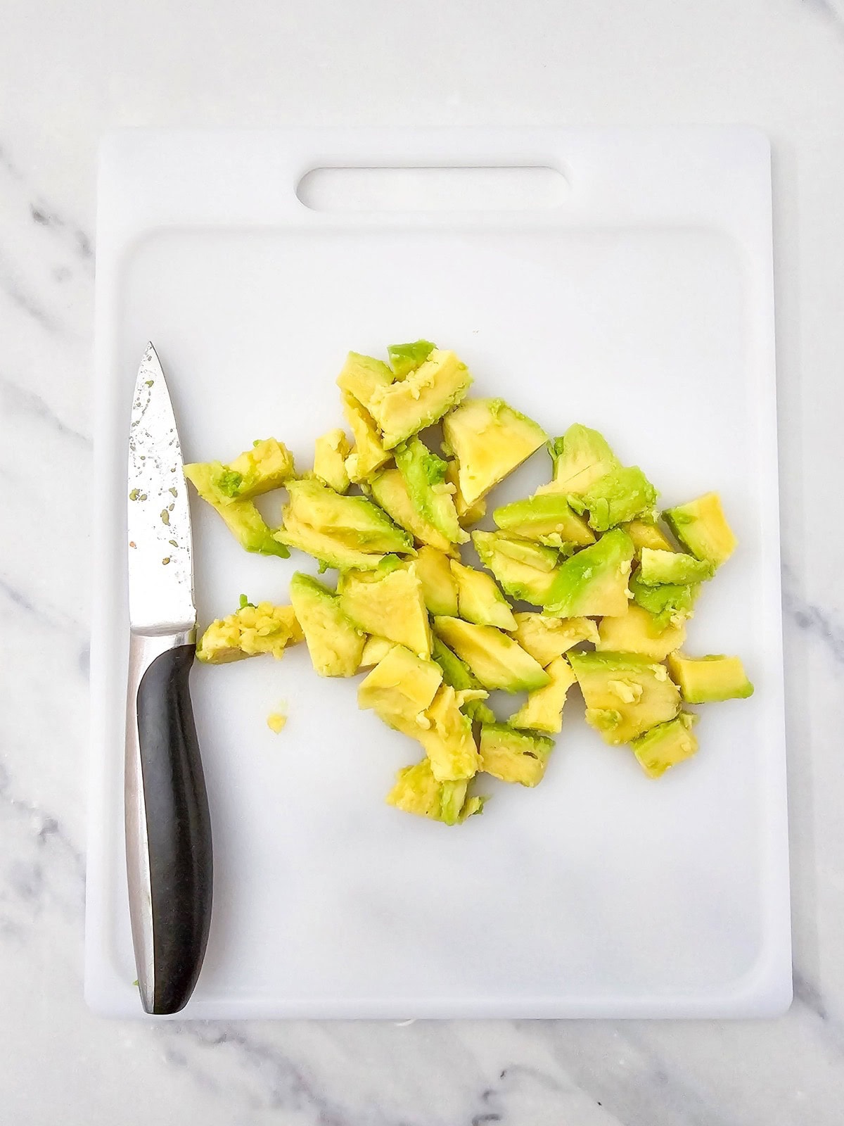 Diced avocado on a cutting board.