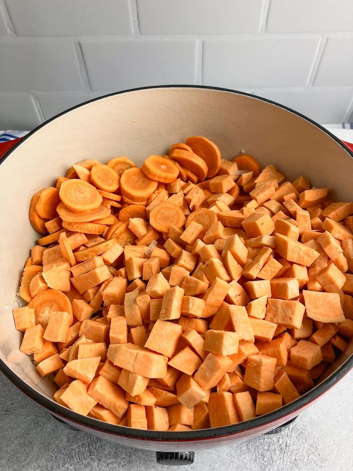 Diced sweet potatoes and sliced carrots were added to the pot.
