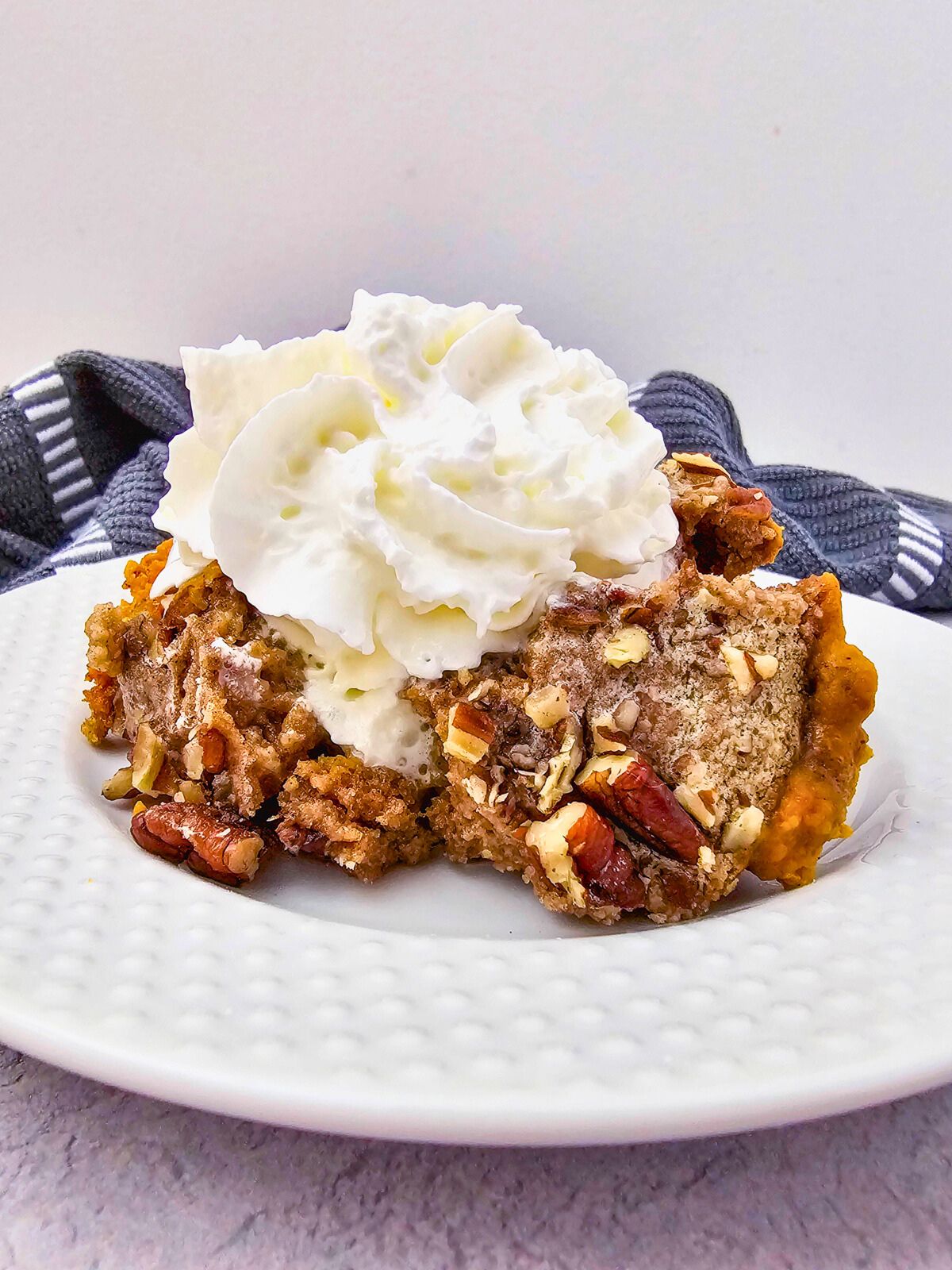 Homemade Crockpot pumpkin dump cake on a white plate.