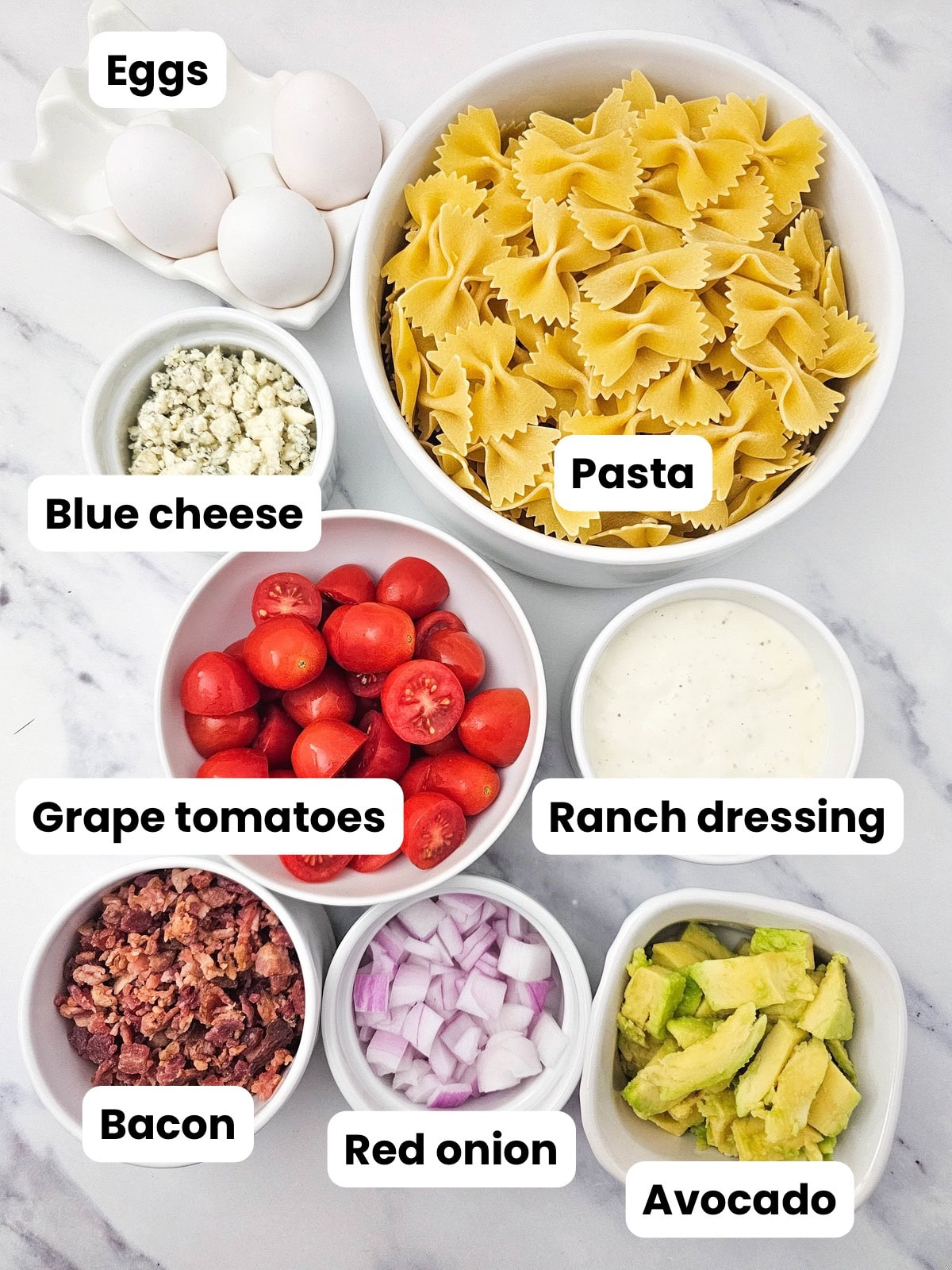 Ingredients for cobb pasta salad were measured into small containers.