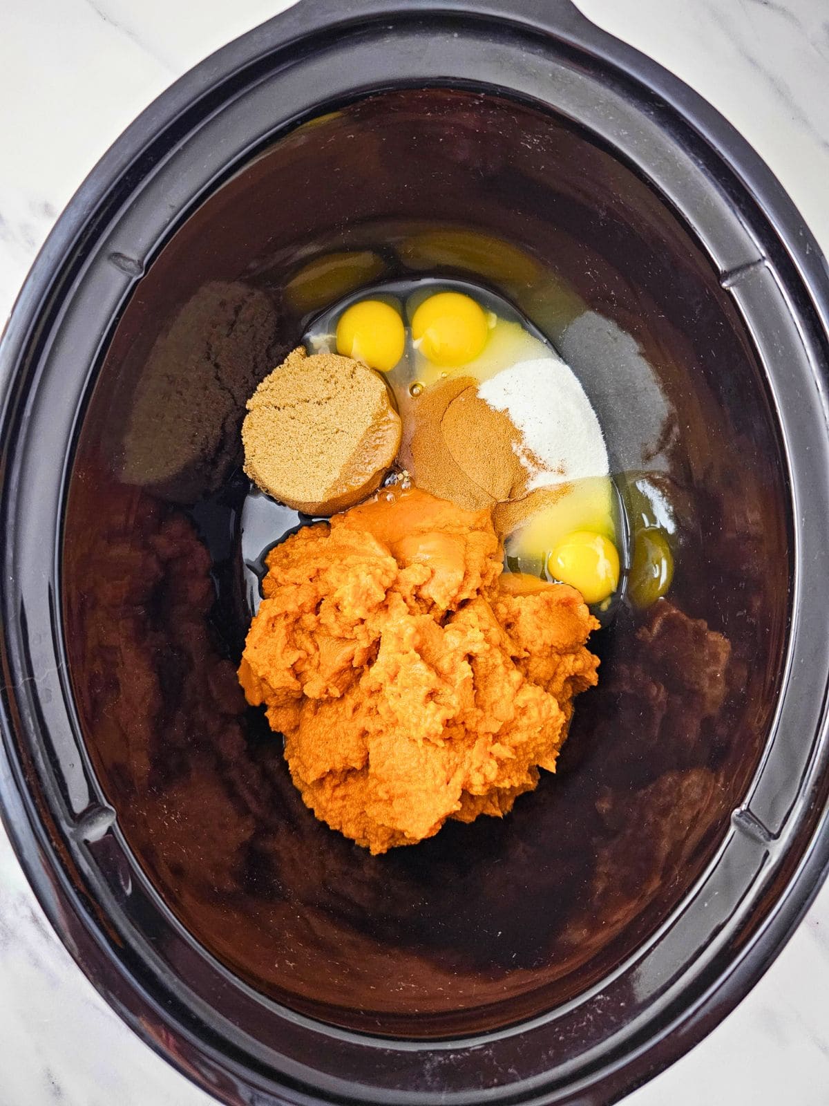 Cake ingredients are added to the crockpot.