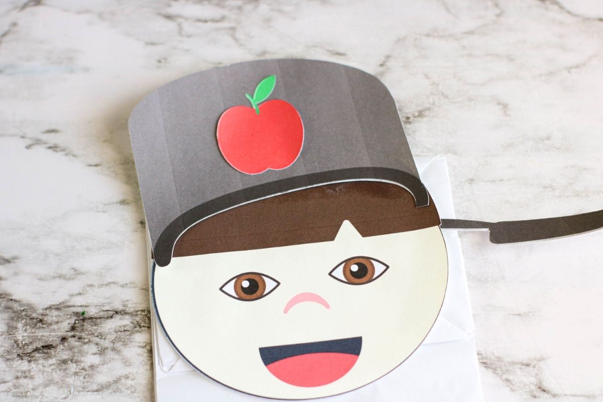 The apple has been glued onto the puppet hat.