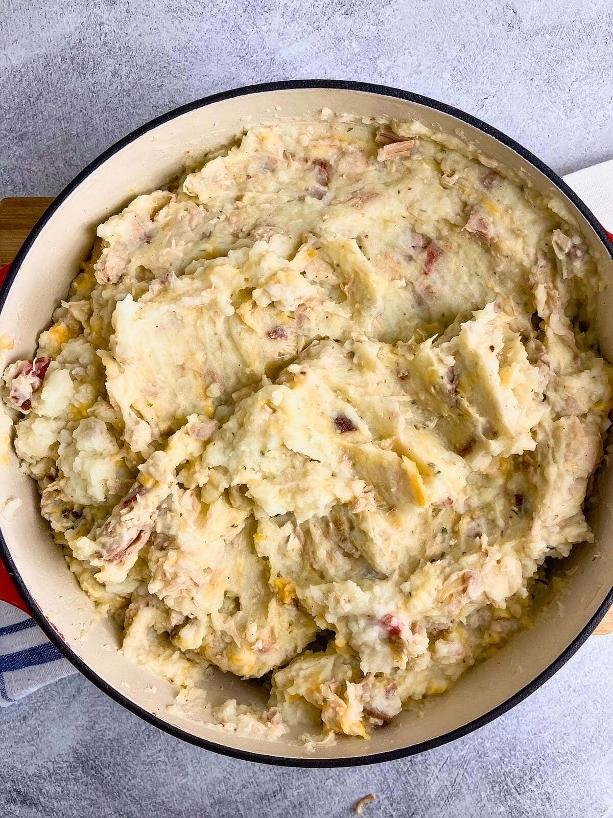 Mashed potatoes with cheese, turkey, and bacon mixed together.