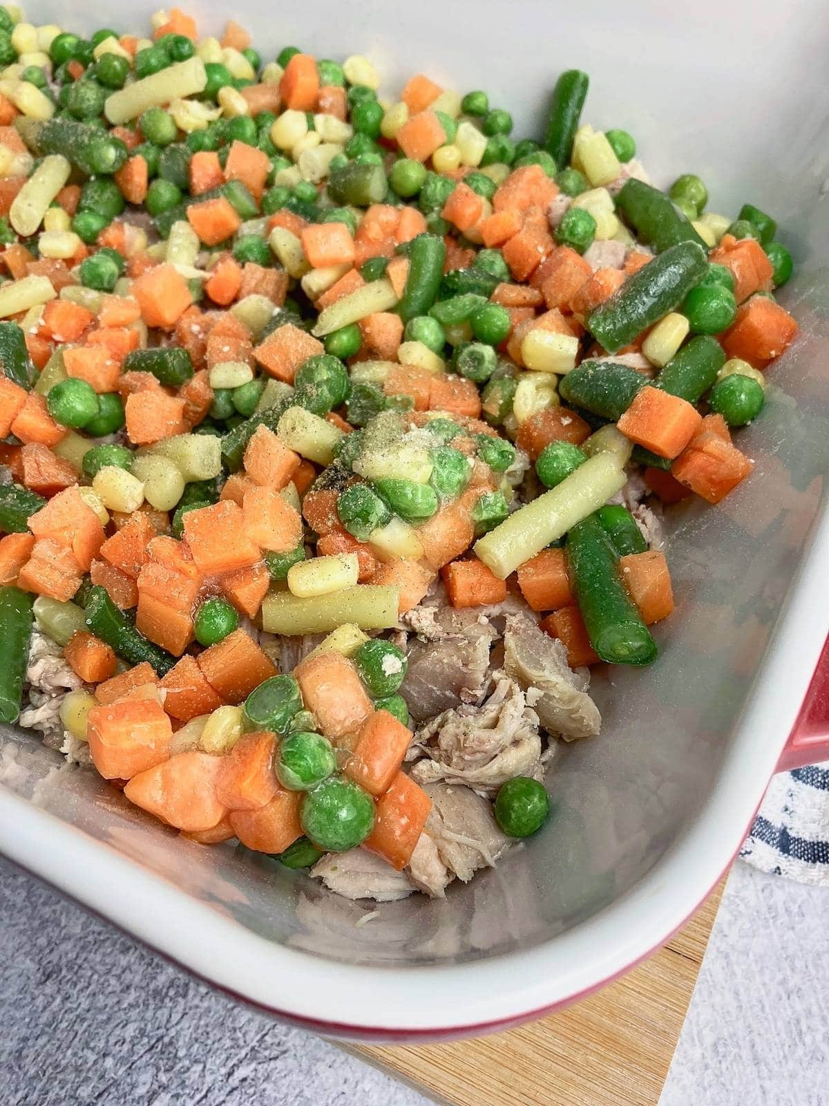 The mixed vegetables and seasonings have been placed over the turkey.
