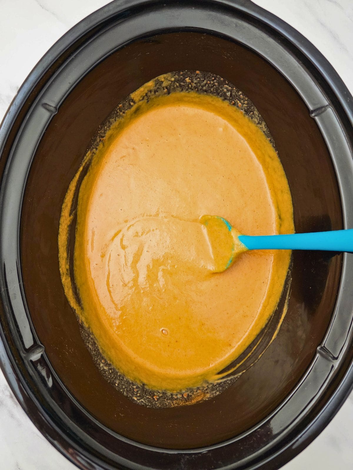 The pumpkin filling is mixed together in the crockpot.
