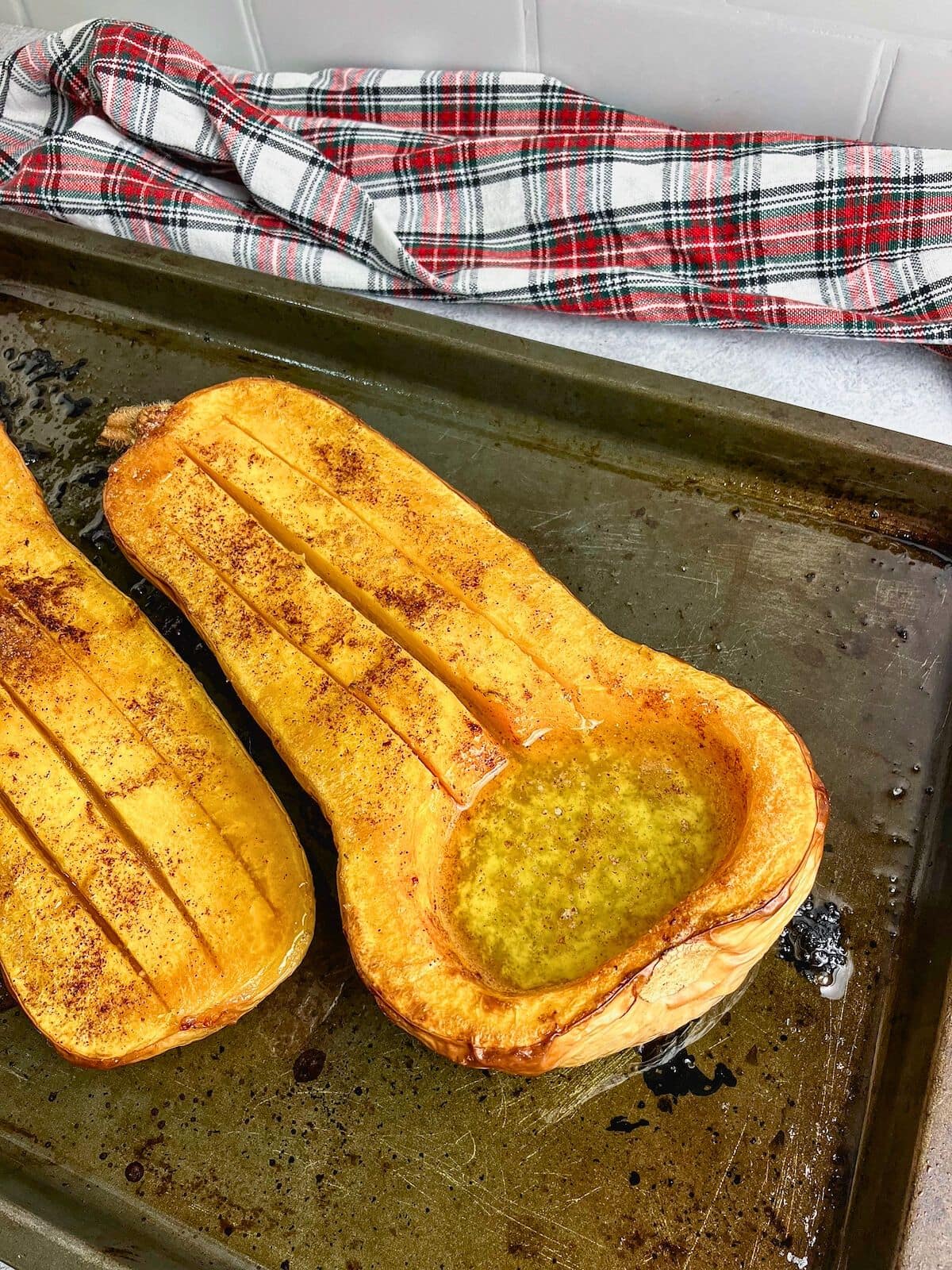 The butternut squash has been scored to let the melted butter and syrup soak through the squash.