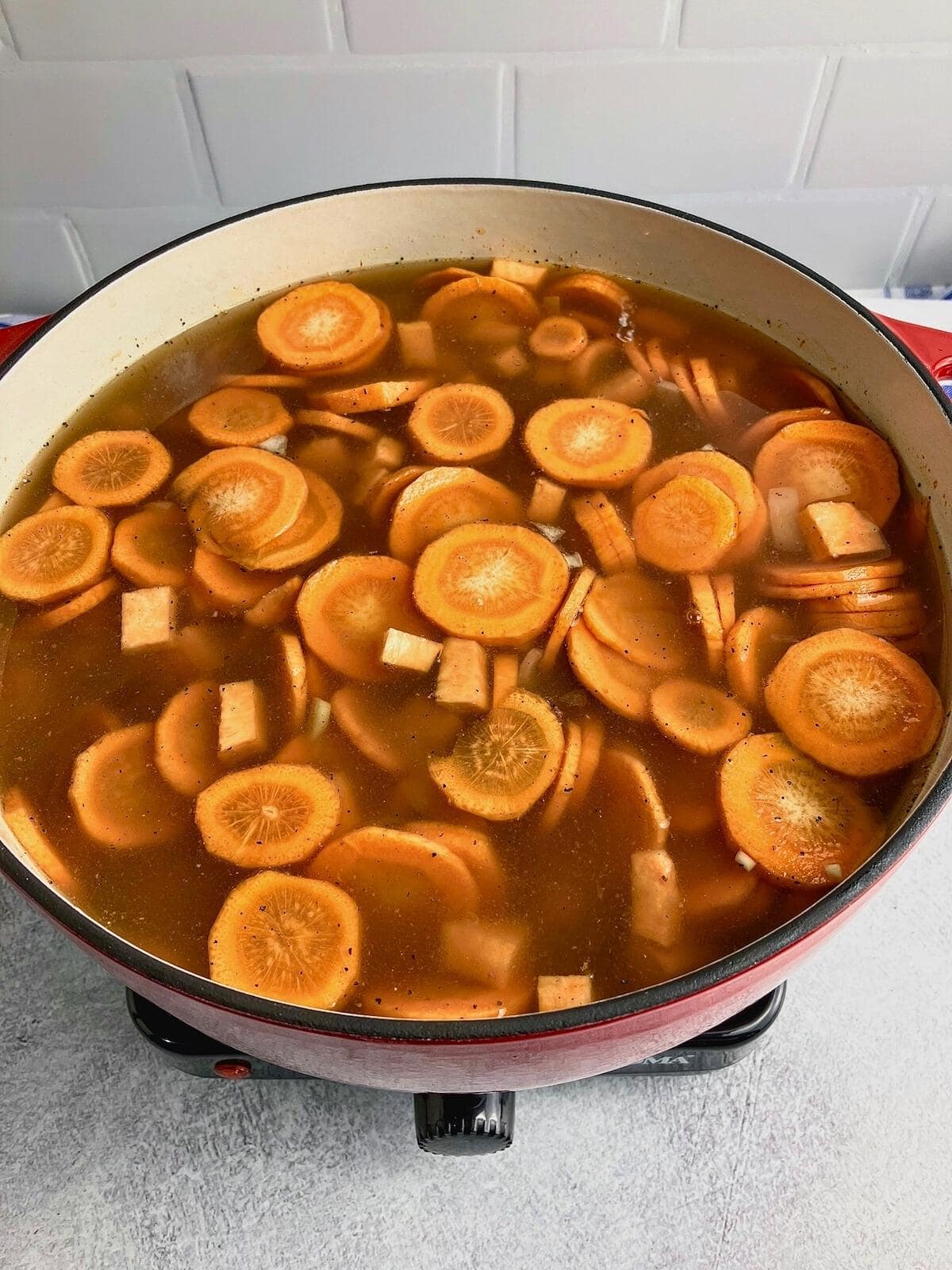 Broth, vegetables, and seasonings are stirred together.