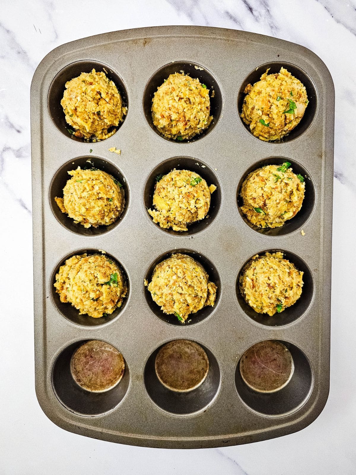 Stuffing mixture has been divided into 9 muffin cups.
