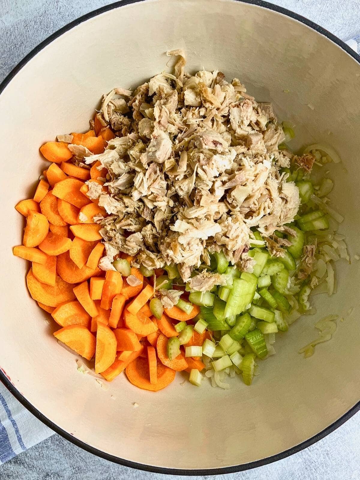 Cooked turkey, carrots, and celery were added to the pot.