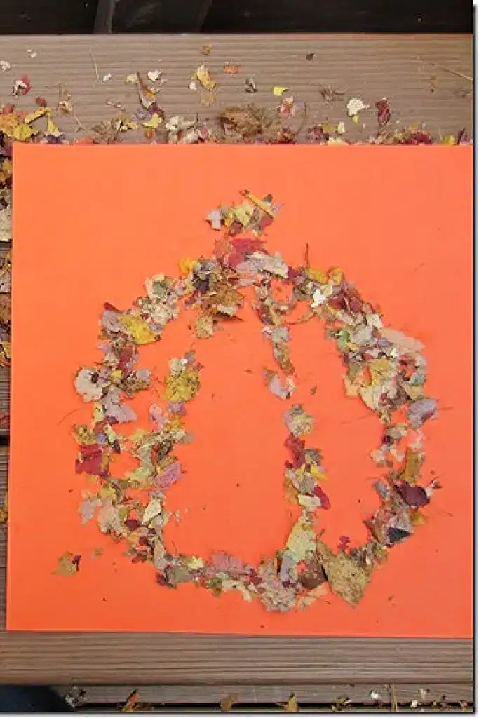 A pumpkin picture craft made from glitter made from fall leaves.