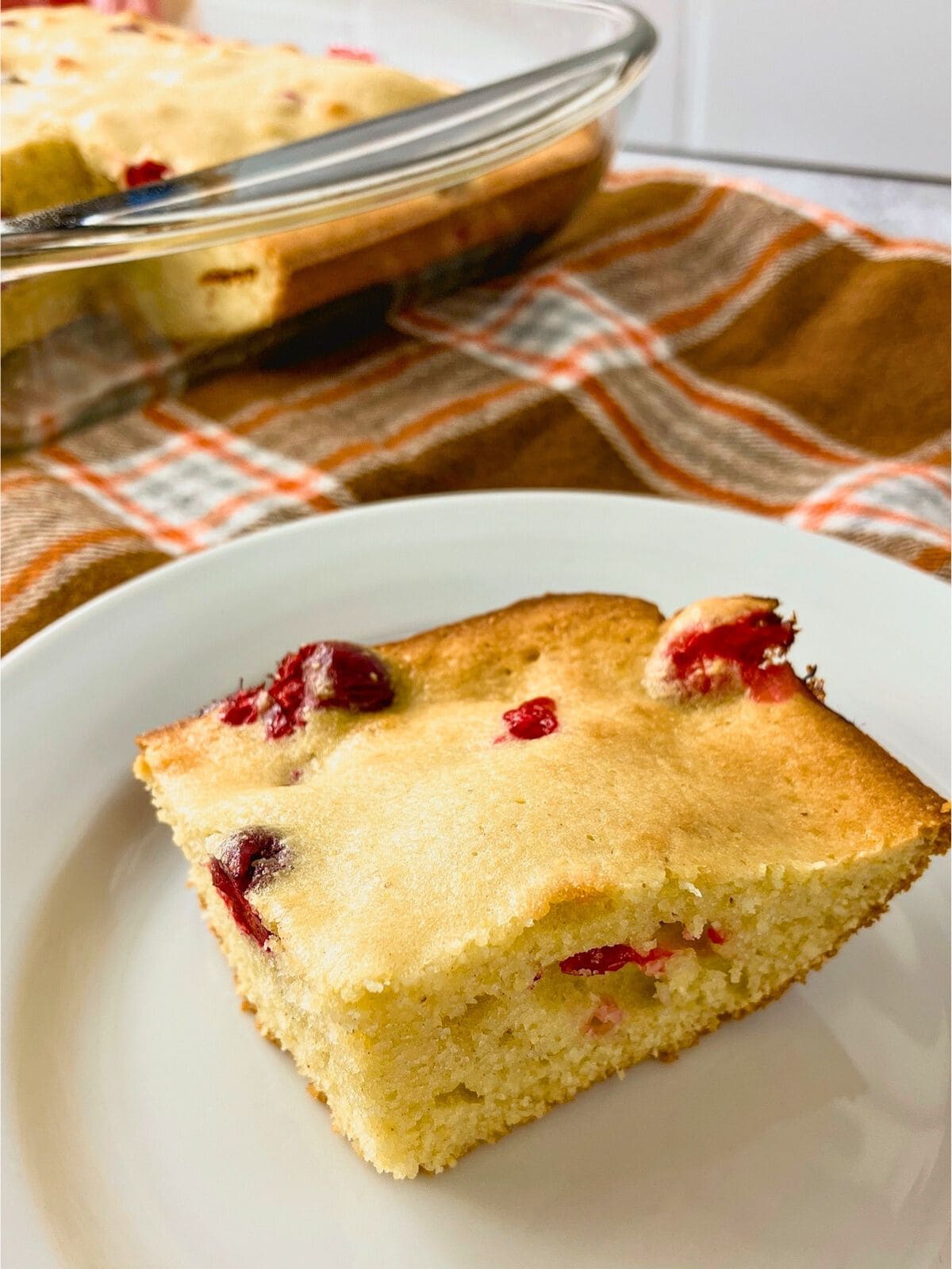 A slice of homemade cranberry cornbread on a plate.