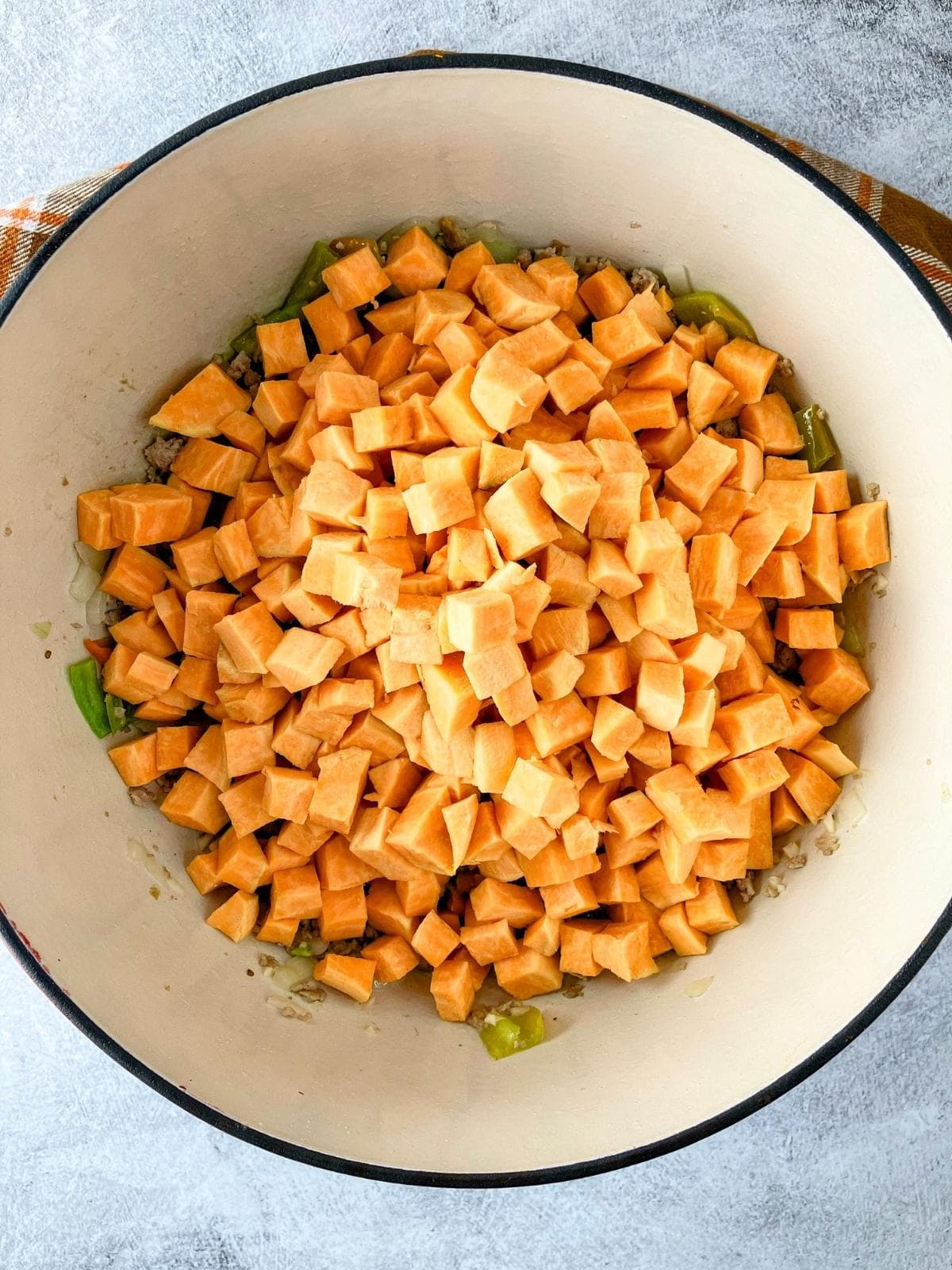 The diced sweet potatoes were added to the cooked meat, onion, and pepper mixture.