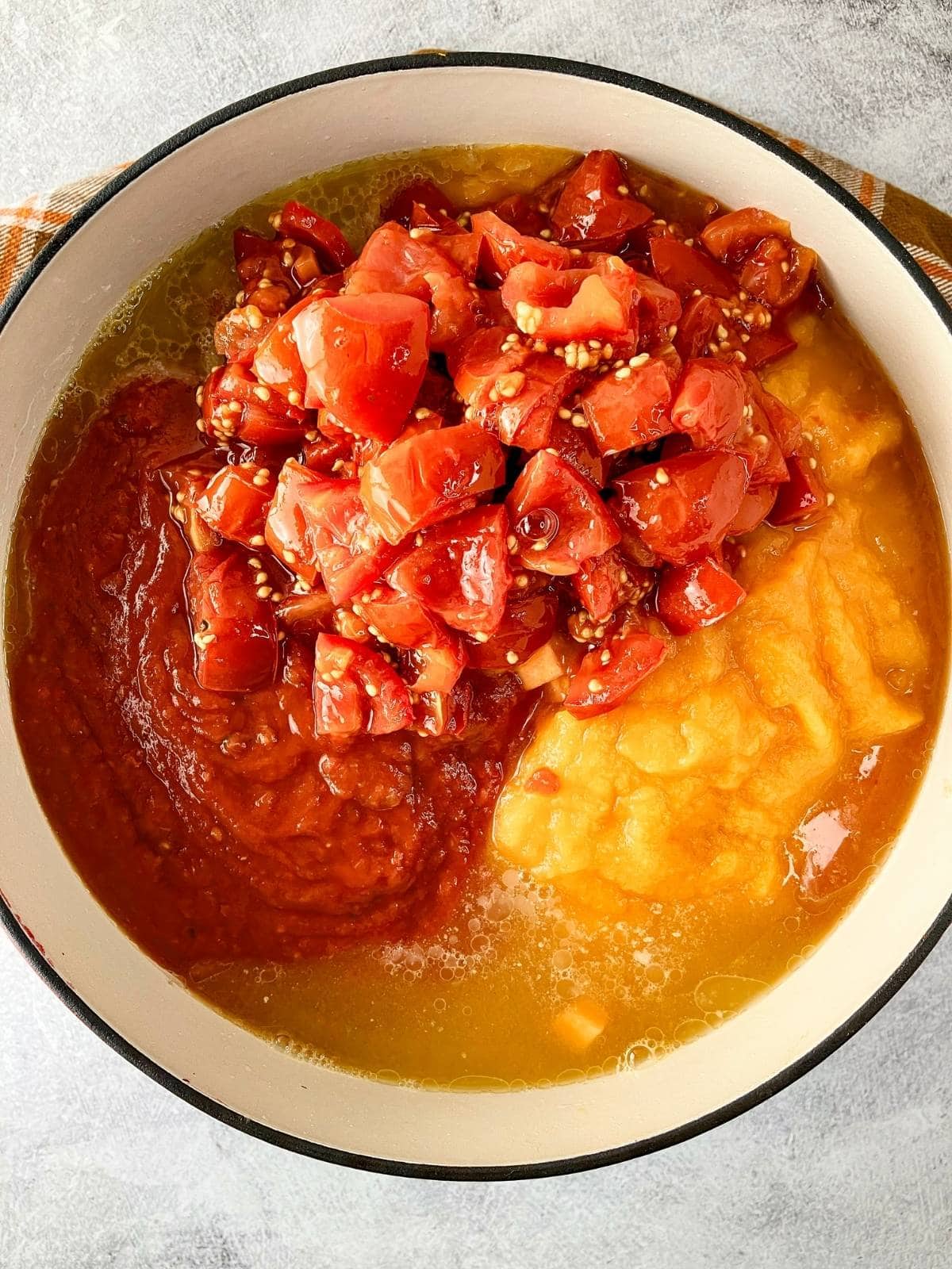 Tomato sauce, broth, and diced tomatoes were added to the pot.
