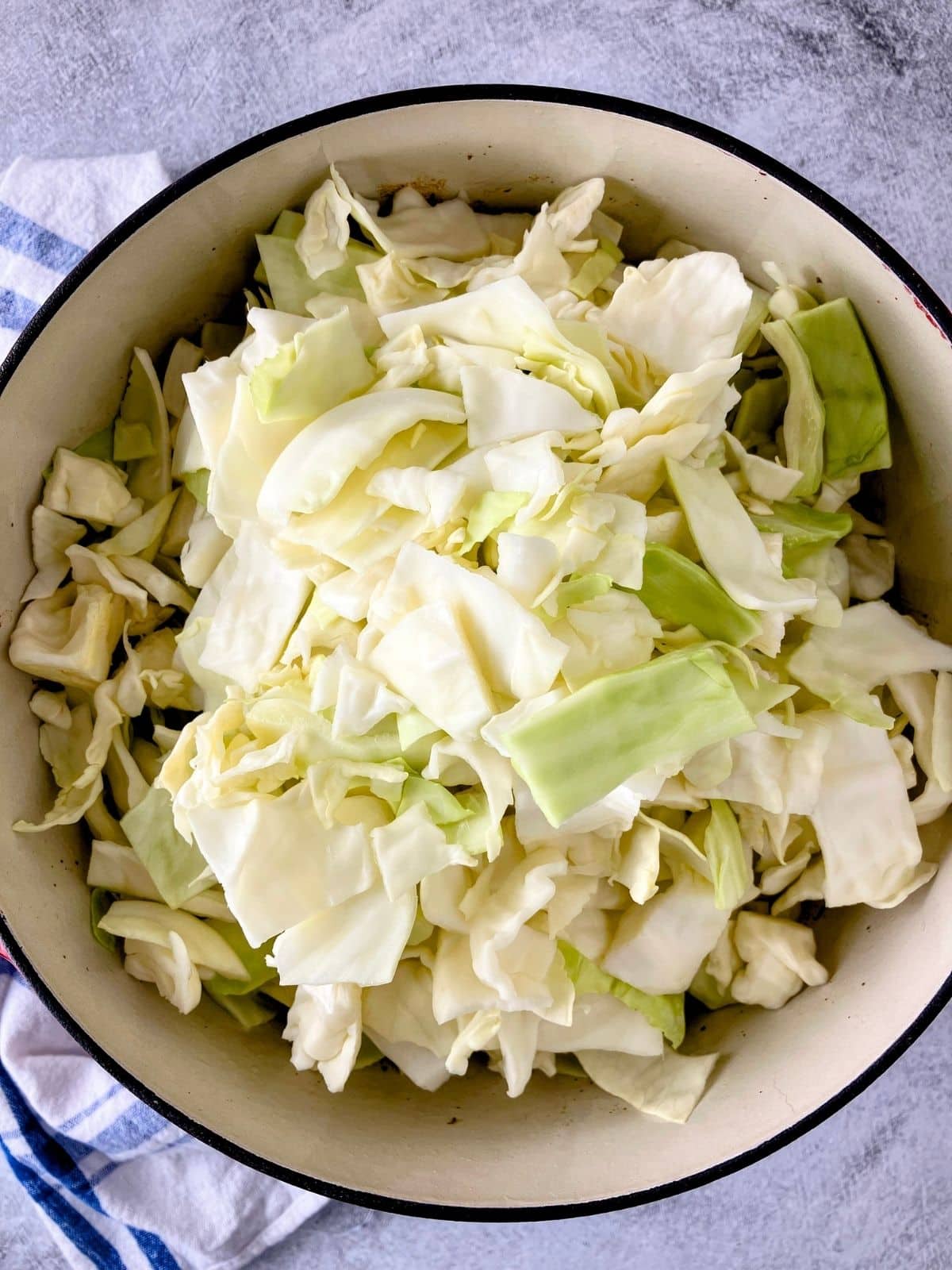 Thickly sliced cabbage is added to the cooked sausage and onion mixture.