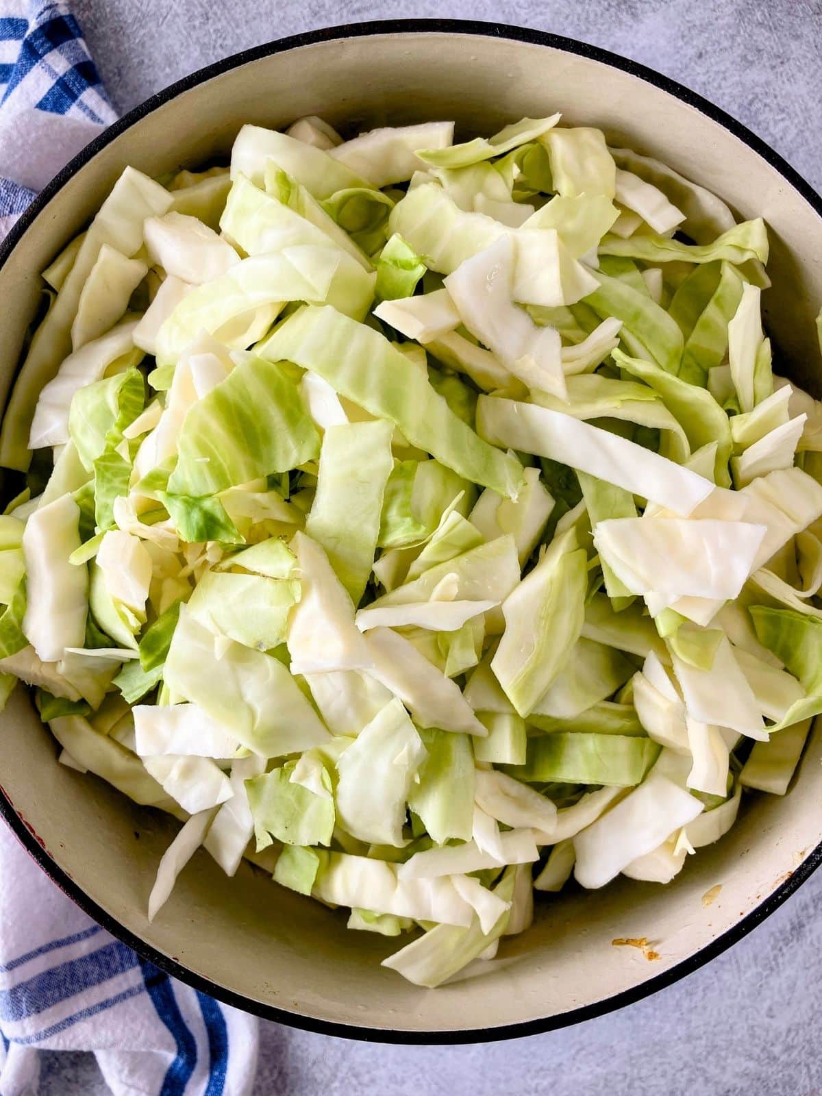 Sliced cabbage added to the meat and onion mixture.