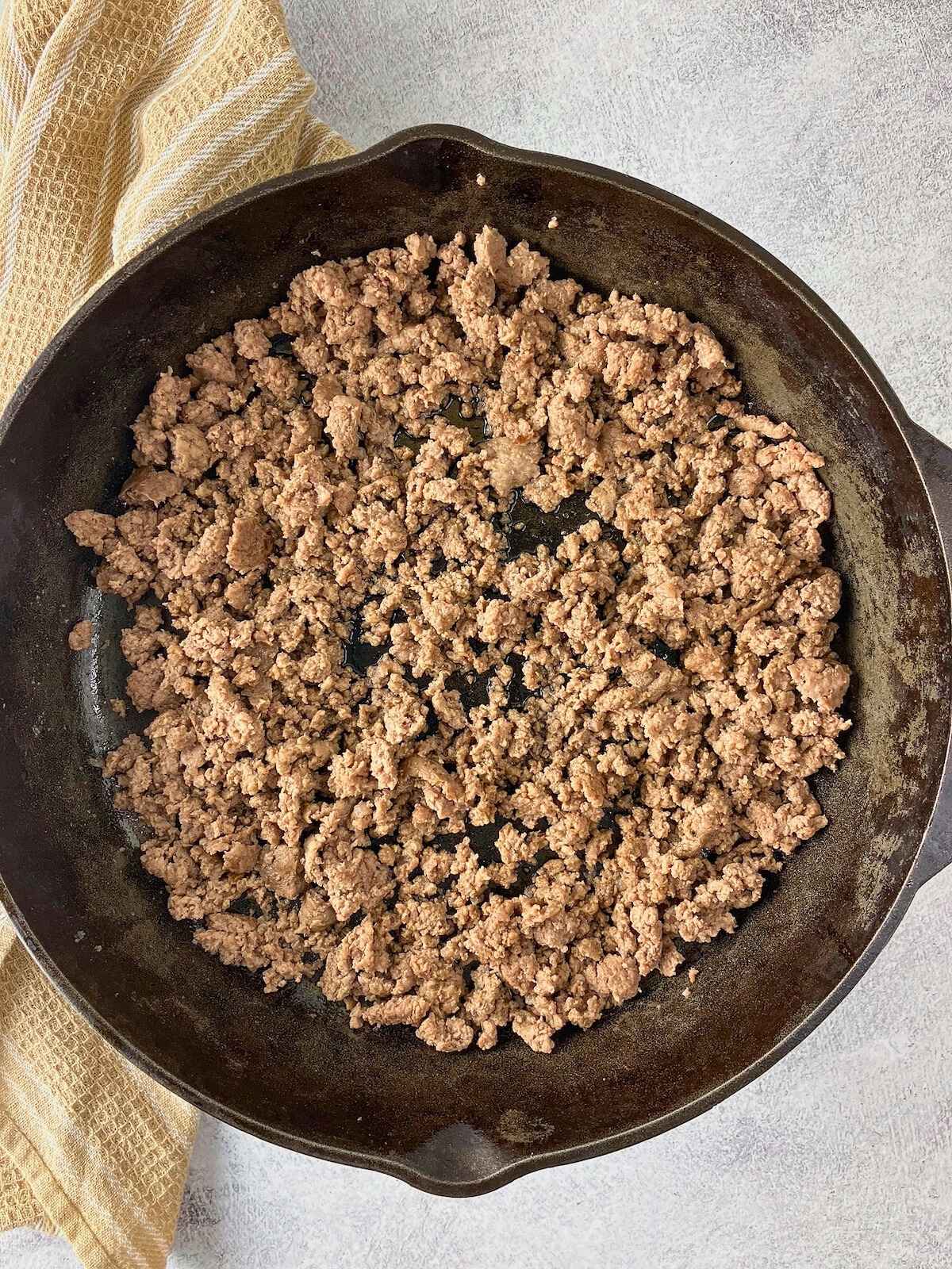 Browned ground beef in a cast iron skillet.