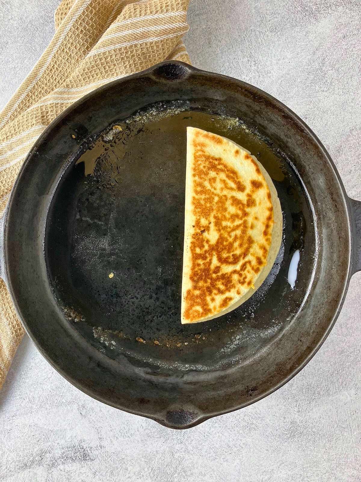 Quesadilla flipped over in the frying pan.