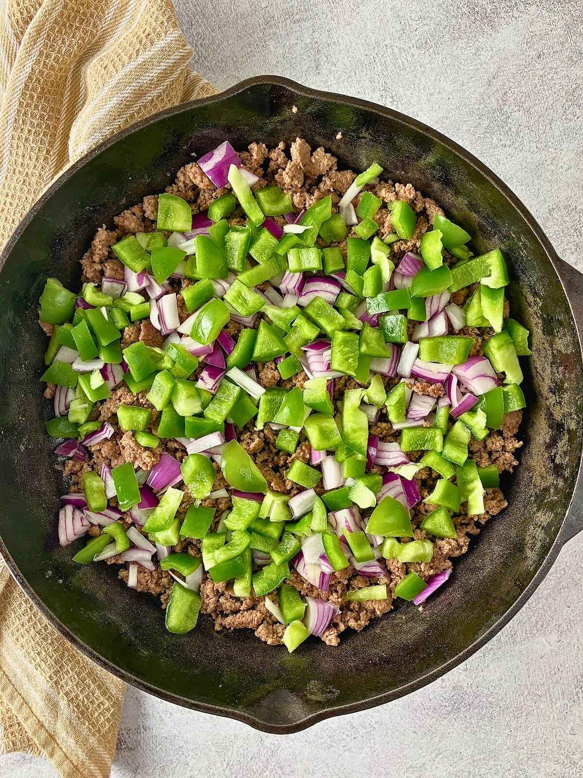 Diced red onions and green peppers were added to the ground beef.