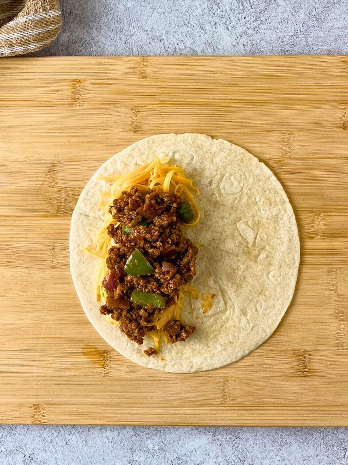 The ground beef filling was added on top of the cheese.