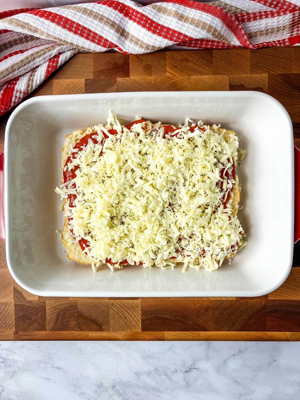 A thick layer of shredded mozzarella cheese was added over the tomato sauce.