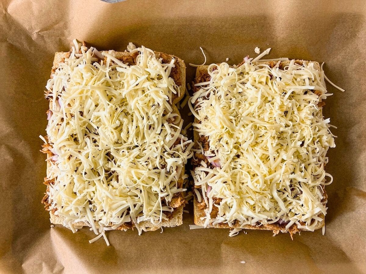 A thick layer of shredded mozzarella cheese was added on top of the chicken and onions.