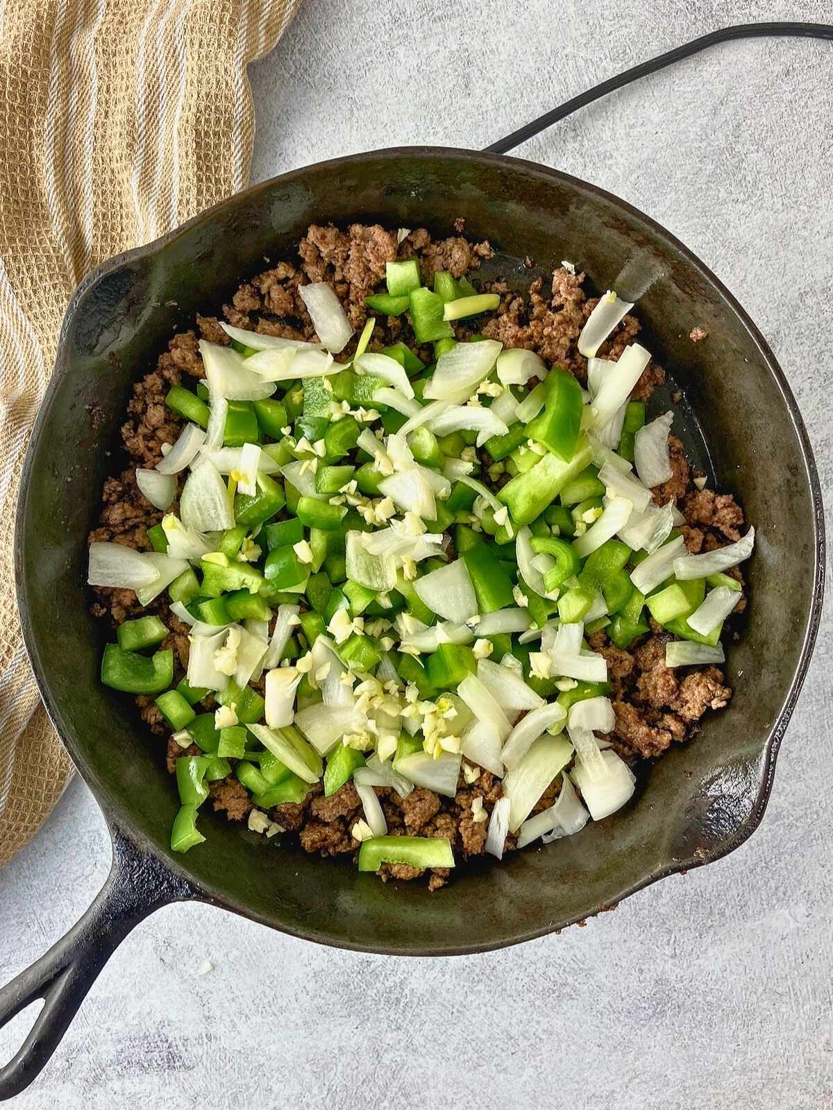 Diced green peppers, onion, and garlic were added to the ground beef.