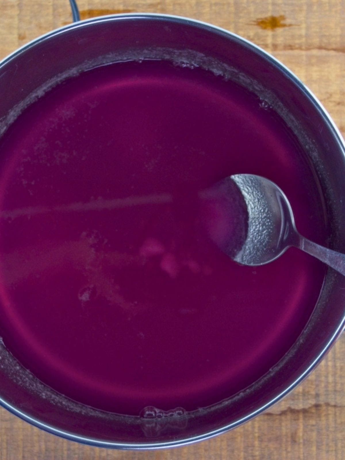 Cooking wild violet jelly in a large pot.