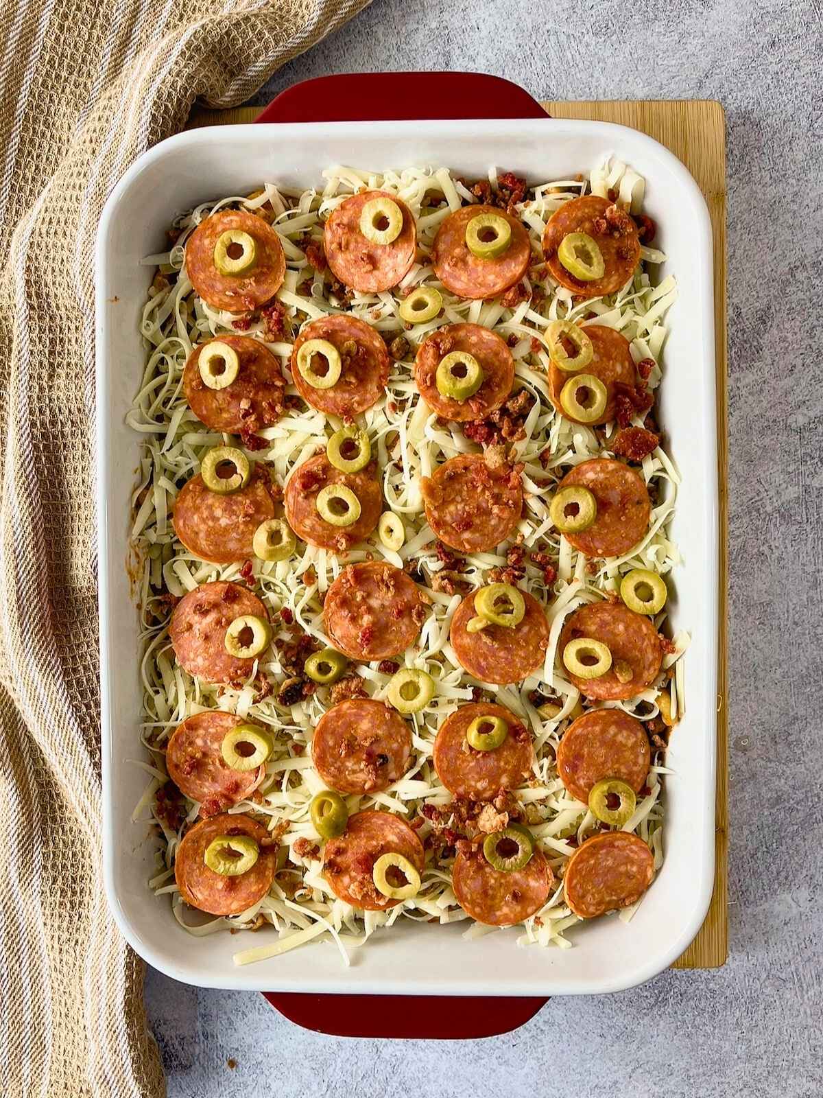 The green olives were added on top of the pepperoni layer.