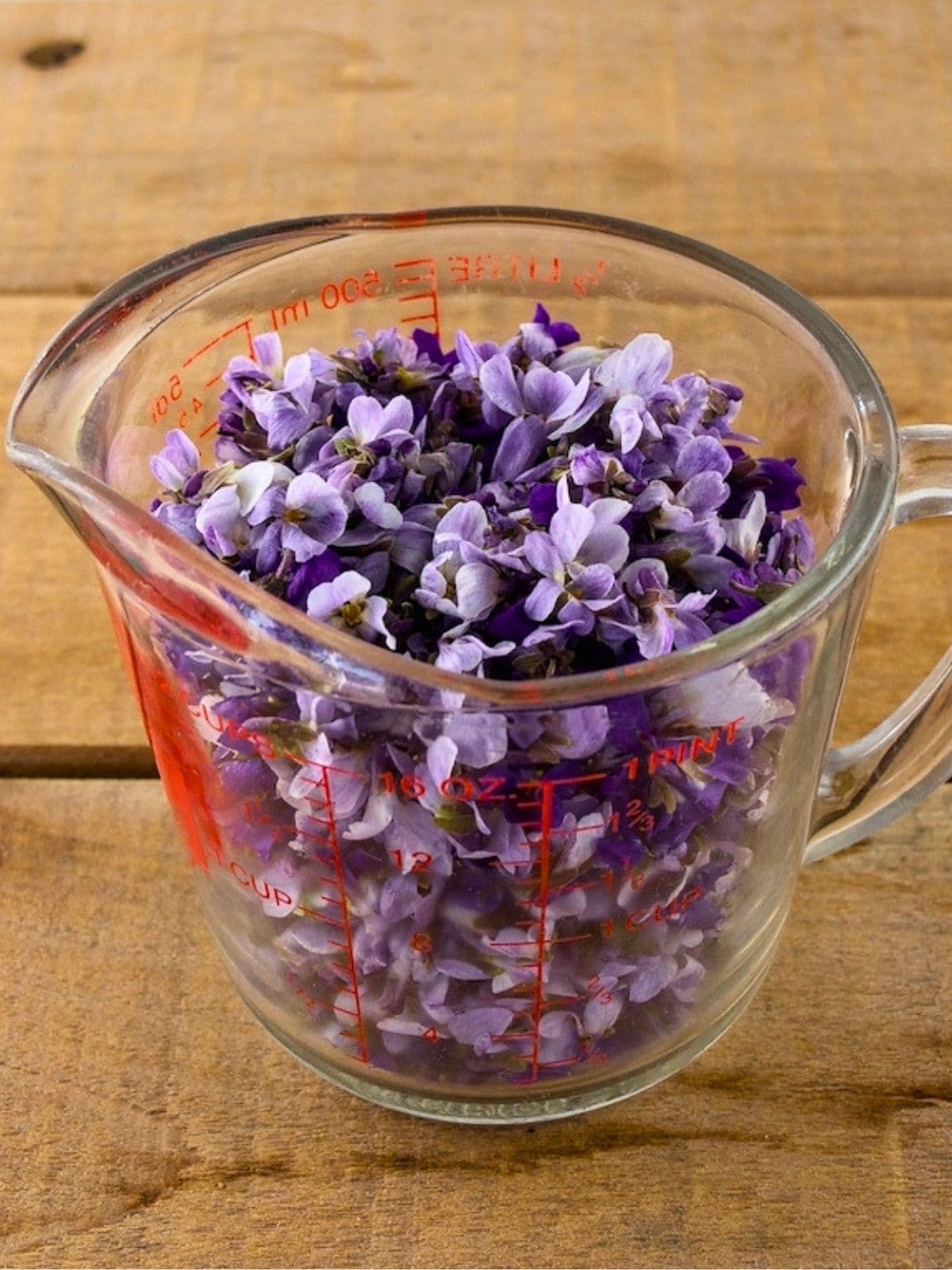 Two cups of violet flowers measured out.