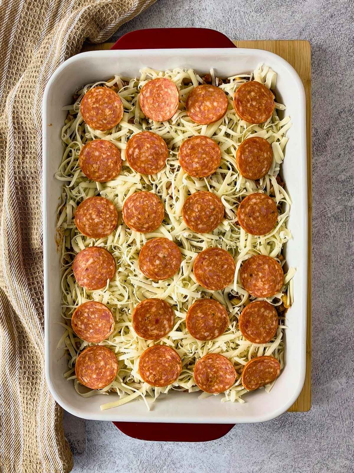 The slices of pepperoni were spread evenly over the cheese layer.