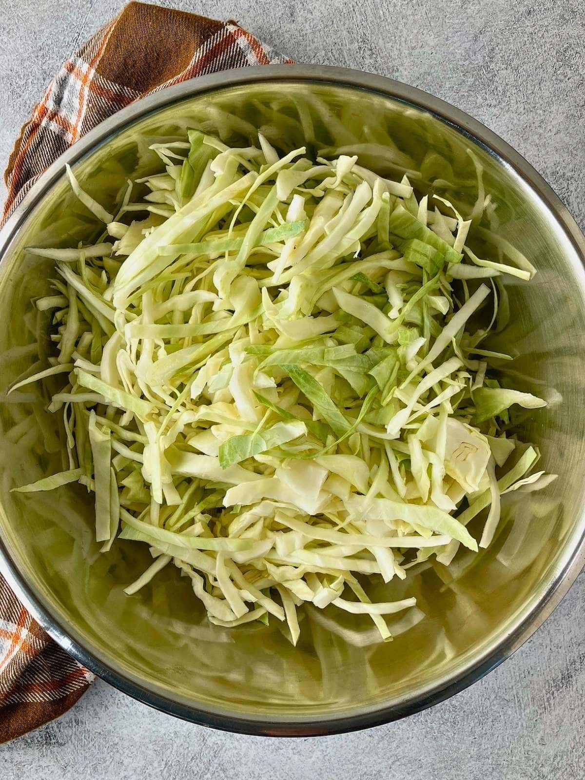 The shredded cabbage was placed into a large mixing bowl.