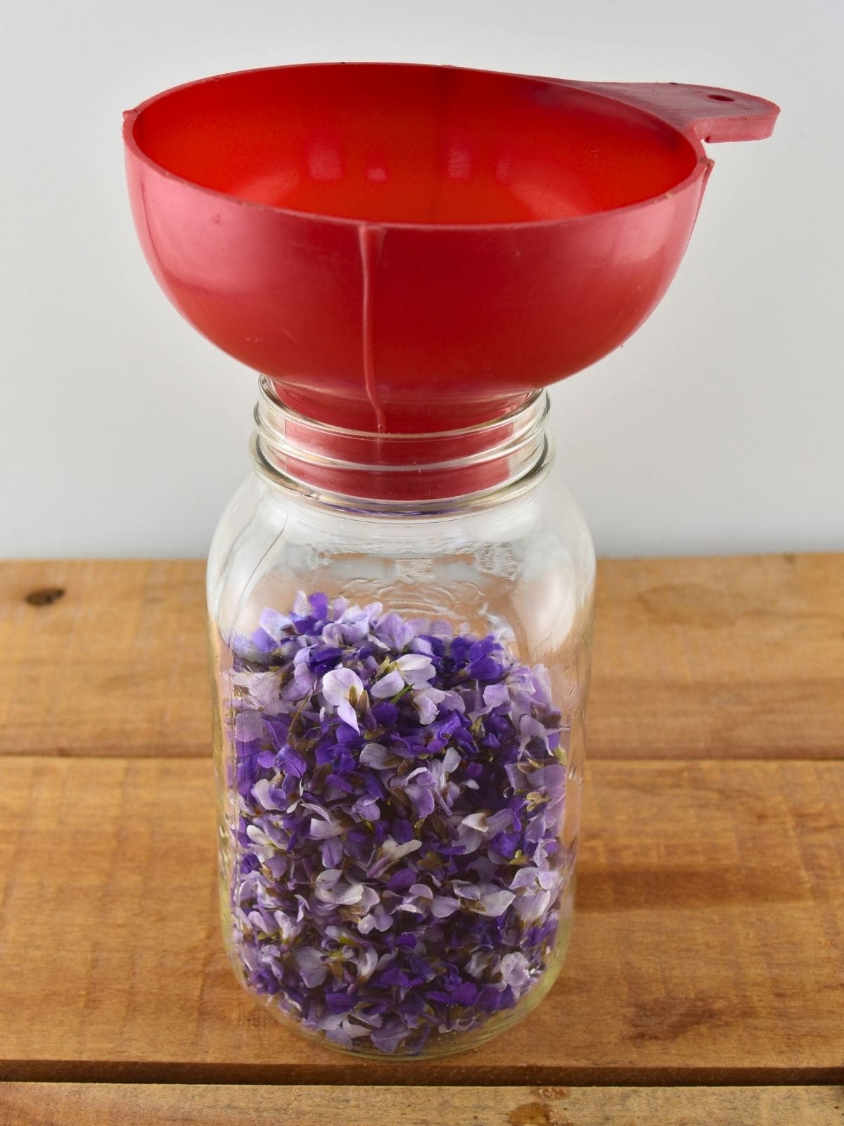 Wild violet flowers were placed into a large mason jar with a canning funnel on top.