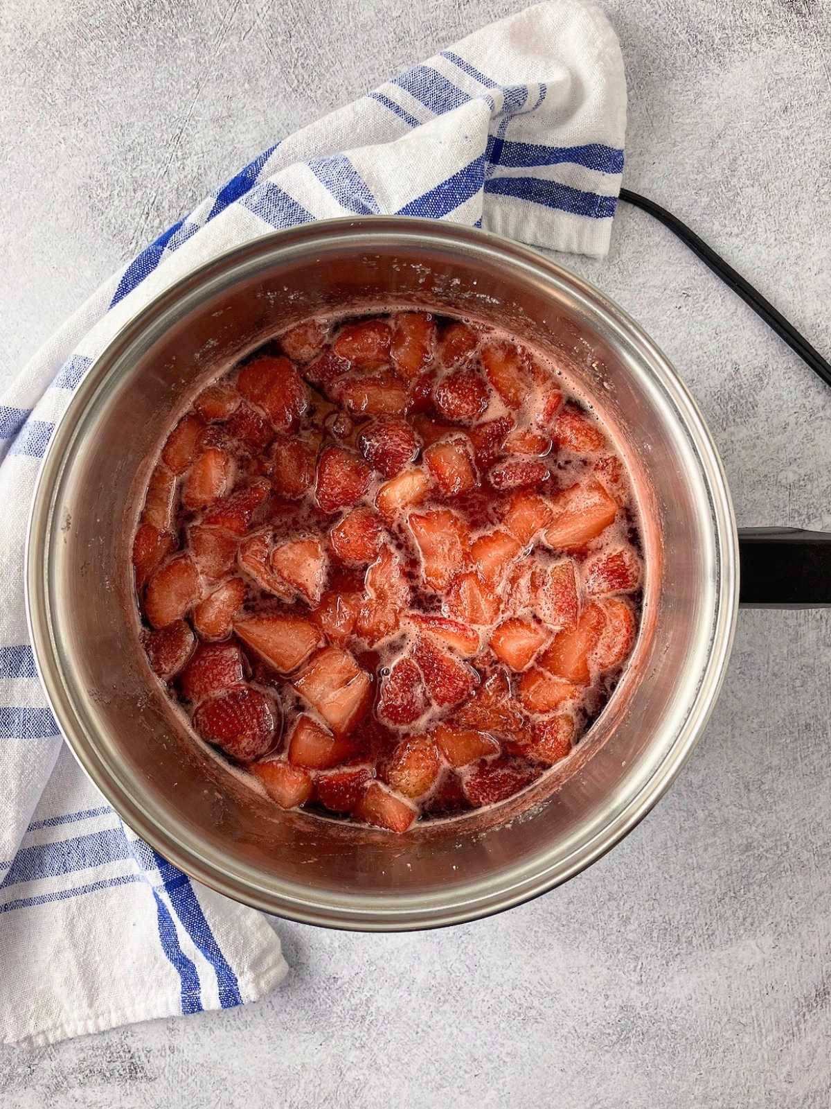 The strawberry compote after cooking in a saucepan.