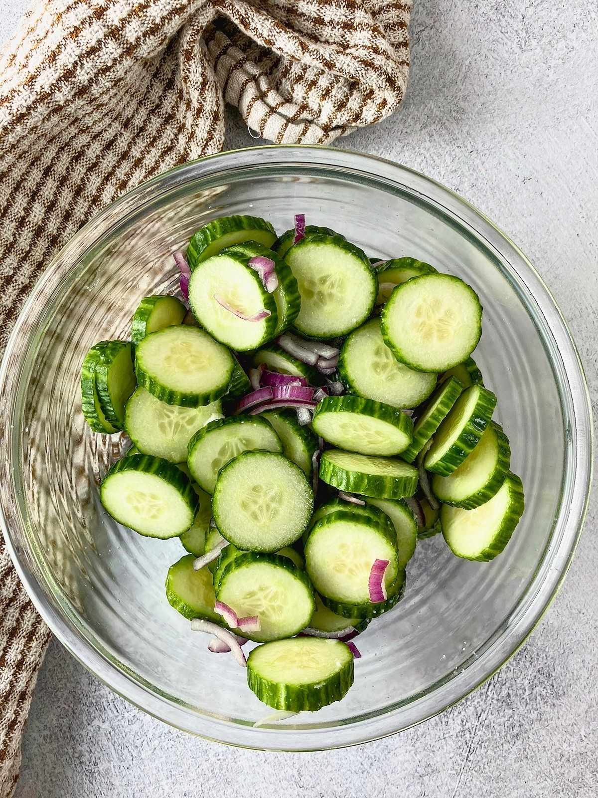 The sliced cucumbers and onions were tossed with salt.