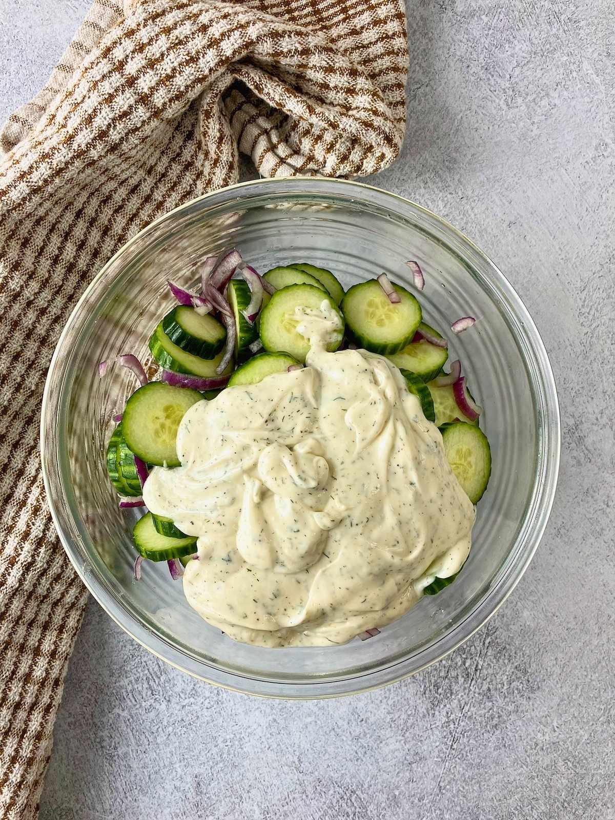 The creamy dressing was poured over the cucumbers and onion.