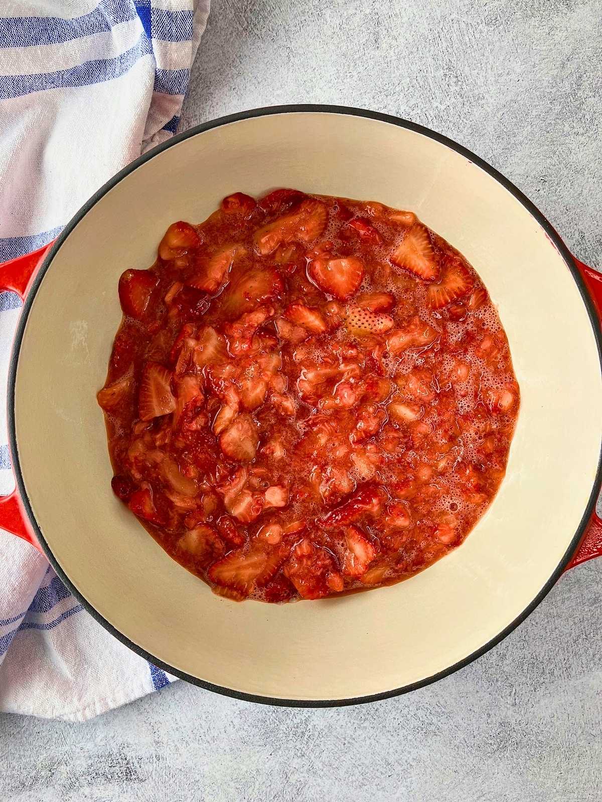 The mashed strawberries were poured into a Dutch oven.