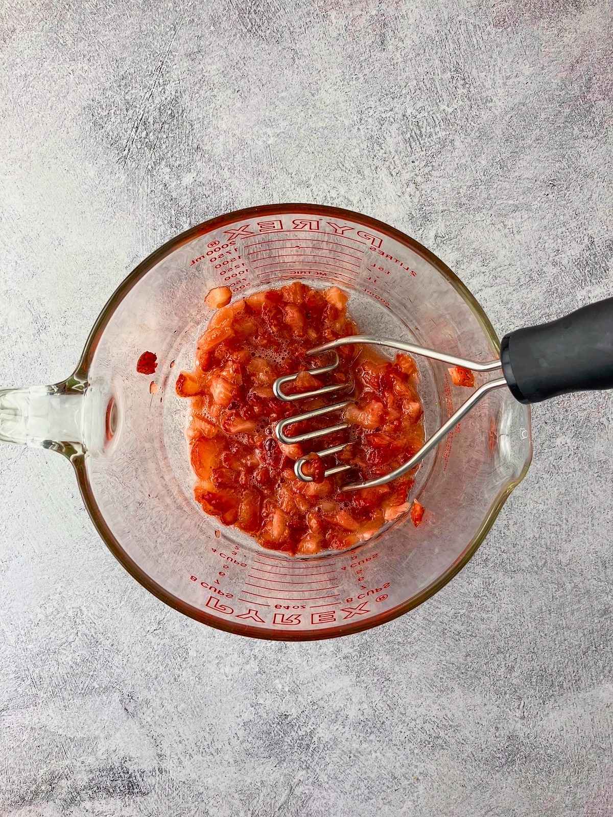 The layer of sliced berries was mashed with a potato masher.